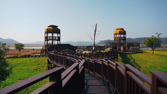 Wooden walkway in a scenic park with an observation tower on a clear day