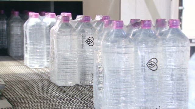 Plastic bottled water moving on a conveyor belt in a factory