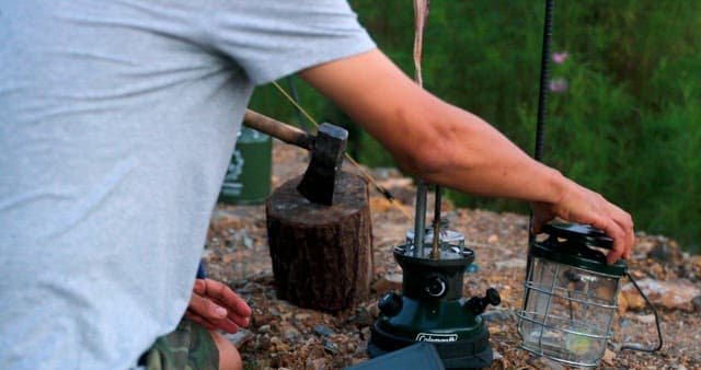 Man Igniting a Portable Gas Stove Outdoors