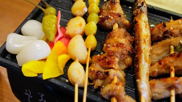 Various types of grilled skewers neatly arranged on an iron plate