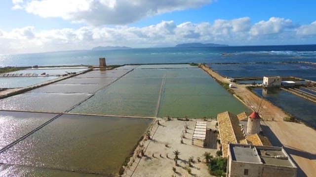 Vast salt pans near the peaceful sea on a sunny day