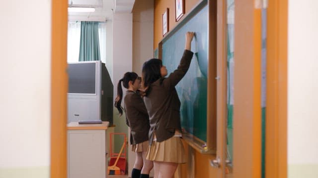 Students scribbling on a classroom blackboard