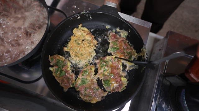 Pan-fried Battered Beef cooked deliciously in oil in a frying pan