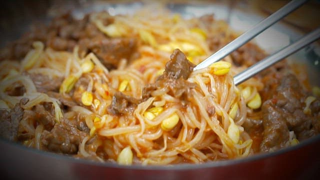 Chopsticks lifting savory bean sprouts bulgogi