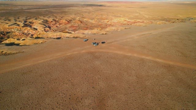 Vehicles in a Vast Desert Landscape