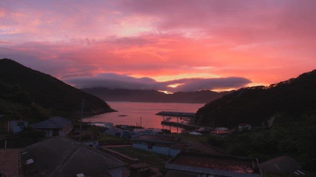 Sunset view over a coastal village with mountains