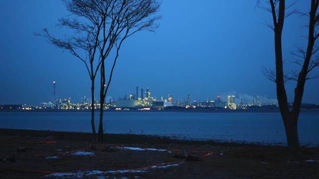 Dusk by the sea with a view of the industrial city