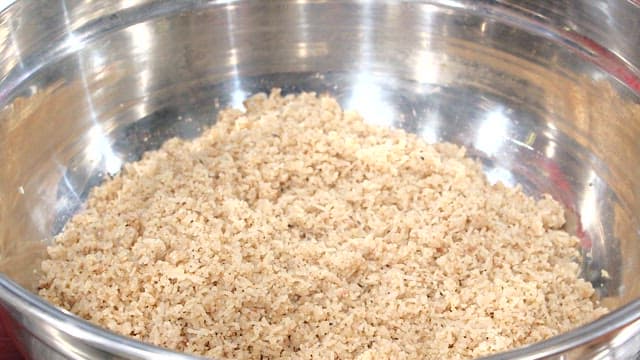 Mixing the minced meat and noodles in a metal bowl
