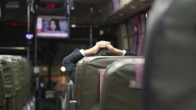 Person Resting Head in Hands in Bus