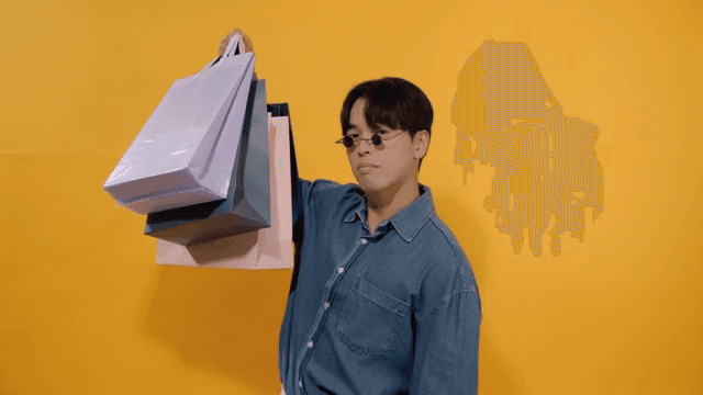 Conceited man wearing sunglasses holding shopping bags