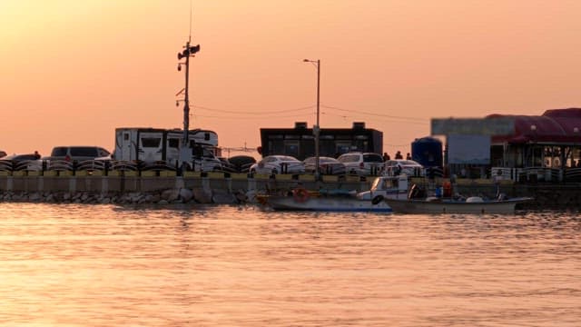 Sunset over a serene harbor with docked boats