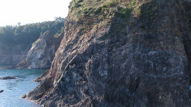 Climber Ascending a Rocky Cliff