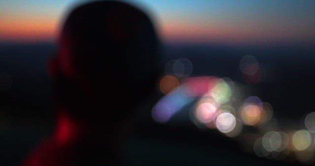 Man Overlooking City Lights at Dusk