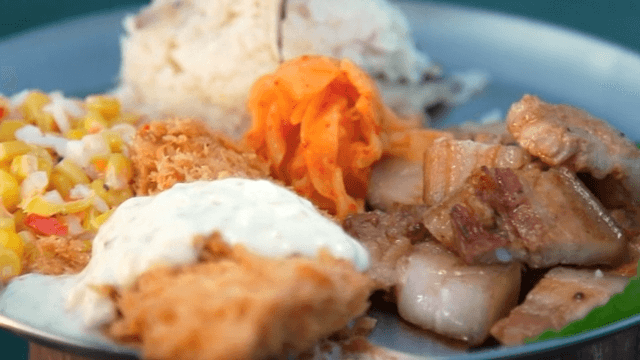 Metal plate with pork belly, corn salad, kimchi, and fried fish