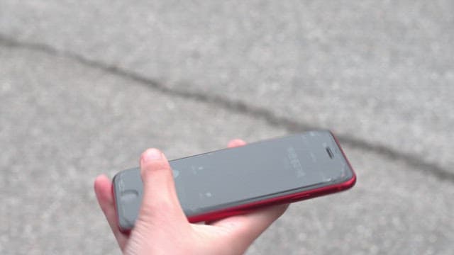 Woman wearing a hat answering the phone on the street
