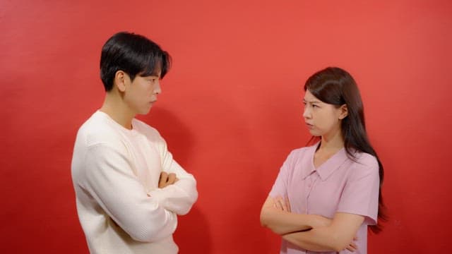 Man and a woman glowering at each other with their arms linked