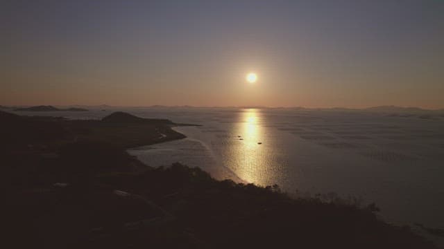 Sunset over a calm sea with distant islands