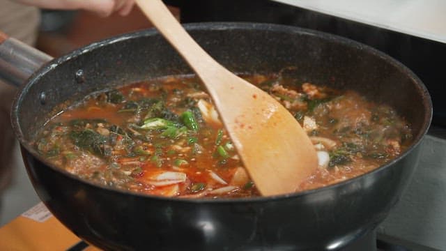Adding Minced Garlic to Spicy and Hot Korean Thistle Stew