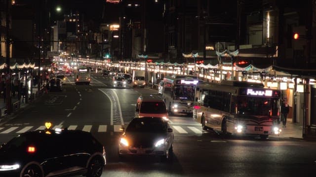 Busy night street with cars and buses