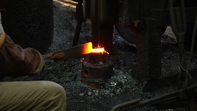 Metal being forged with sparks flying