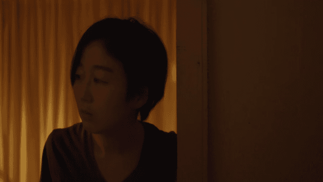 Woman opening the door of a dark room