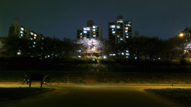 Nighttime cityscape with cyclists passing by