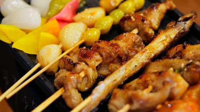 Various types of grilled skewers neatly arranged on an iron plate