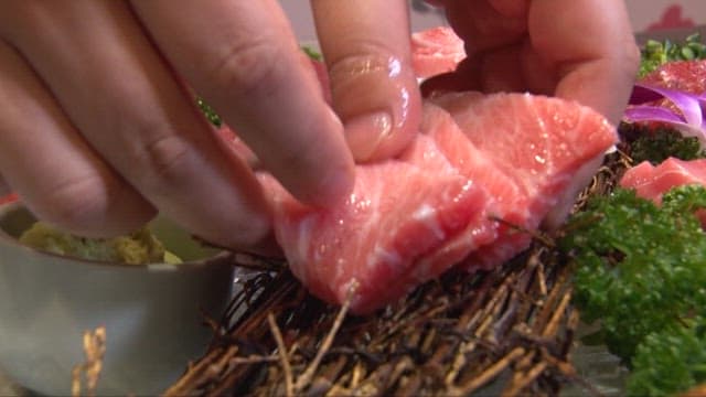Fresh tuna sashimi being prepared on a vibrant platter