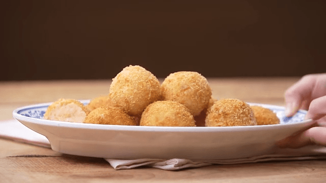 Plate of golden-brown fries served gently on a napkin over a wooden table.