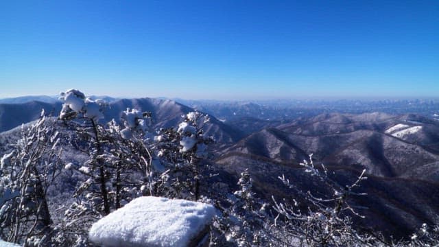Valley of magnificent snow-covered mountains under a clear blue sky