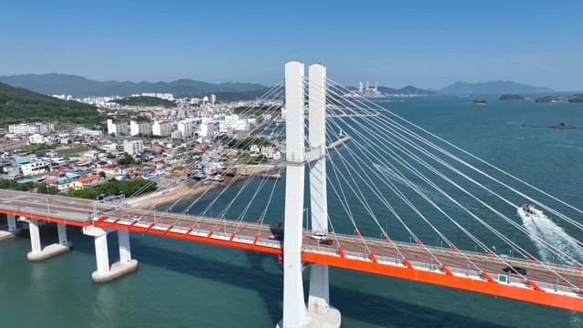 Bridge over a coastal city with mountains