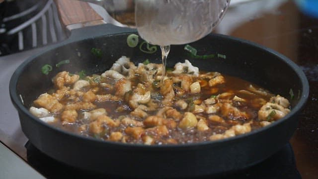 Adding syrup to conger eel being cooked in a frying pan