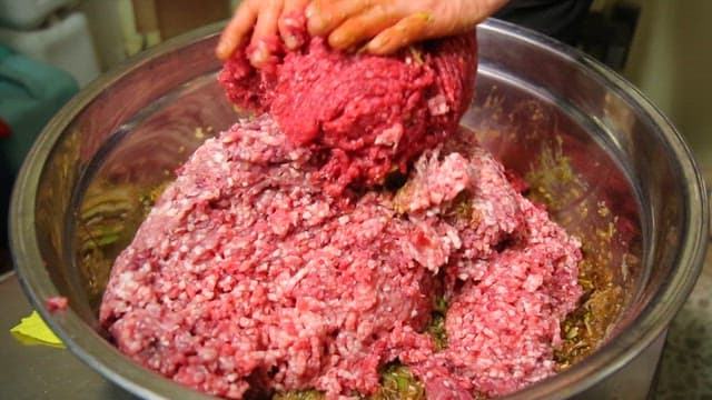 Mixing minced meat with spices in a bowl