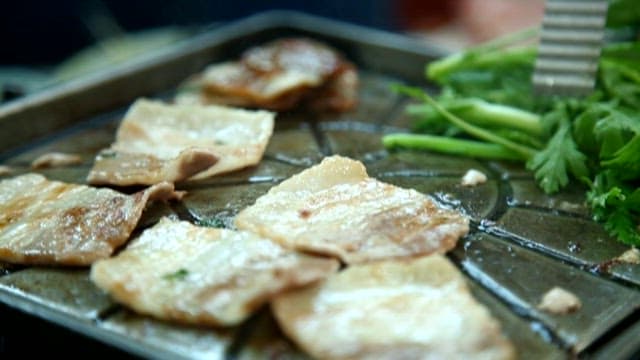 Pork belly and crown daisy on a stone plate