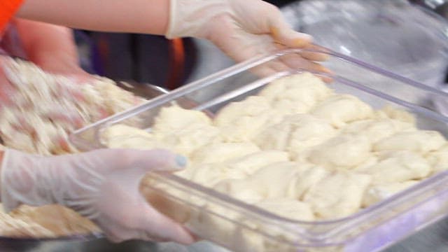 Hand-pulled dough being prepared in a kitchen
