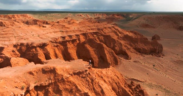 Person standing on a red desert cliff
