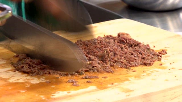 Chopping cooked bulgogi on a wooden board