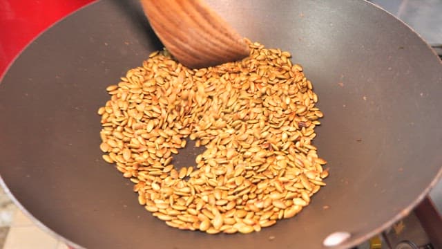 Toasting sunflower seeds in a pan with a spatula