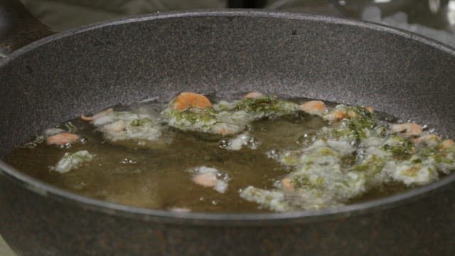 Vegetables fried in a frying pan with oil