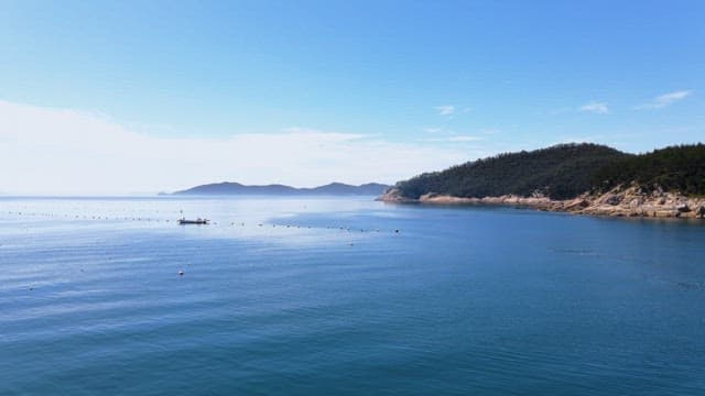 Calm sea with distant islands and a boat