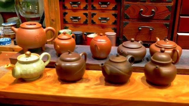 Various traditional teapots on wooden table in antique atmosphere