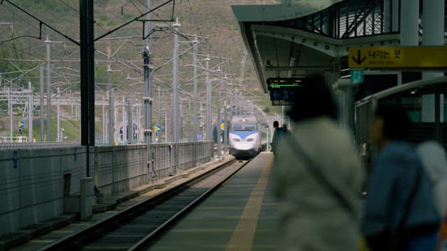 Train Approaching Station as Passengers Wait