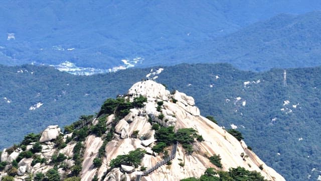Buramsan mountain peak with hikers and a flag