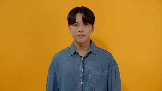 Man in denim shirt smiling brightly, expressing joy