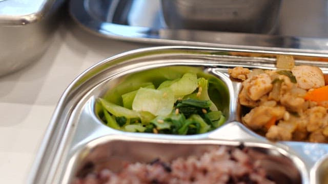 Rice, soup, and various side dishes served on a metal tray