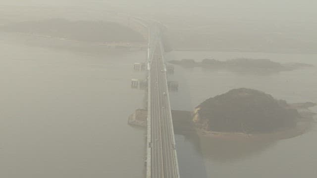 Aerial View of a Bridge Over a River in Hazy Atmosphere