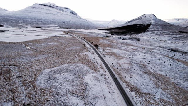 Snowy mountains and road with cars