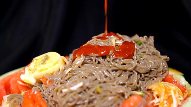 Spicy sauce added to cool cold noodles