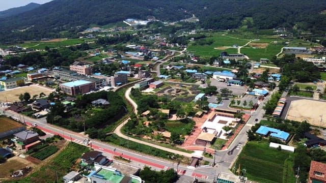 Quiet village with lots of greenery with mountains in the background