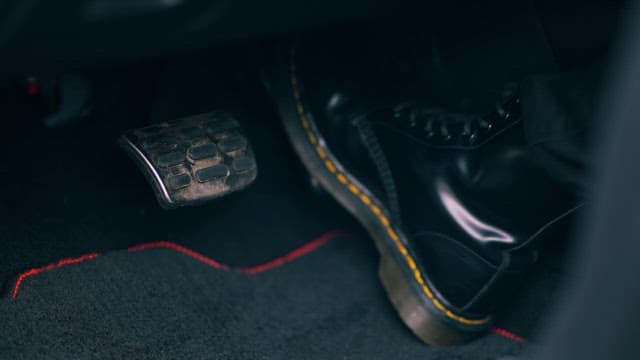 Close-up view of a foot pressing a car pedal